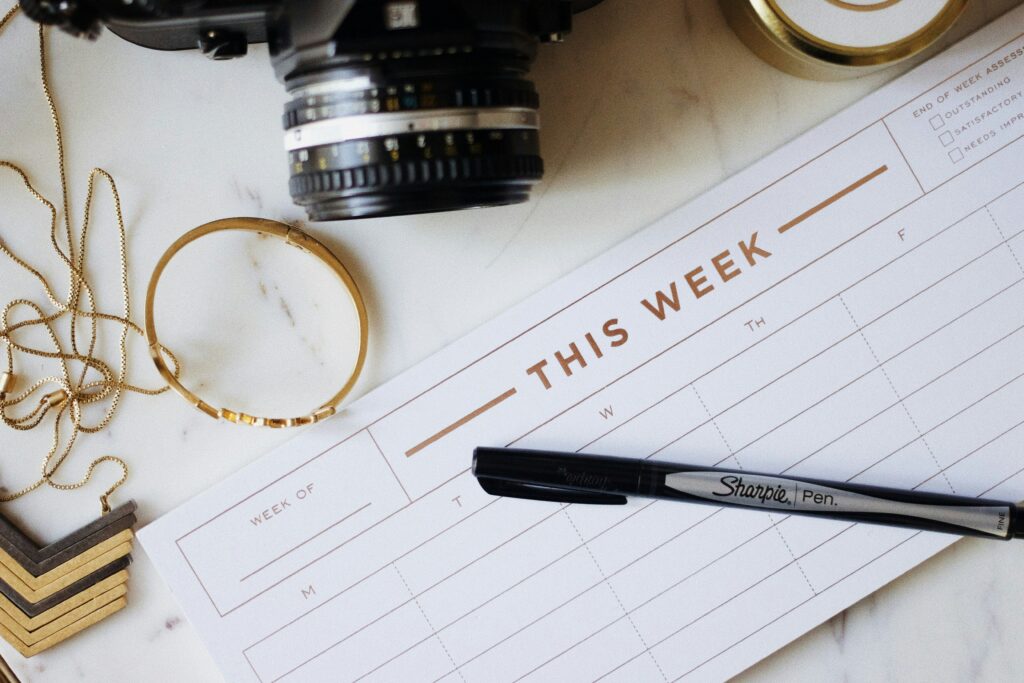 image of a weekly blank calendar with a pen, camera flat lay on table